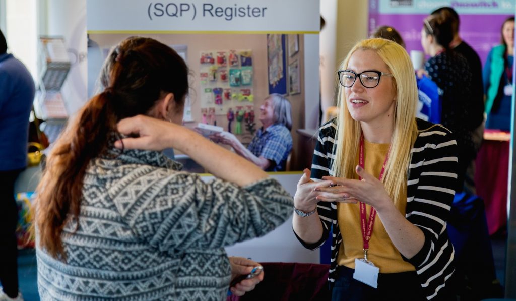 Exhibitor speaking to delegate at previous Clinical Coach Congress event