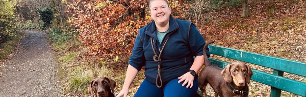 Emily sitting on a bench with two dogs